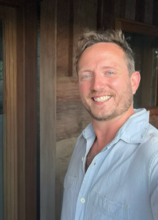Peter Nathaniel Lee smiling in a pale blue shirt
